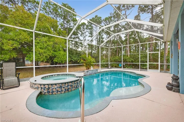 Relaxing pool / spa with a sunroom, a patio, and a lanai