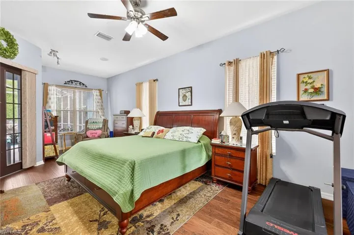 Bedroom with access to outside, dark wood-style floors, and ceiling fan
