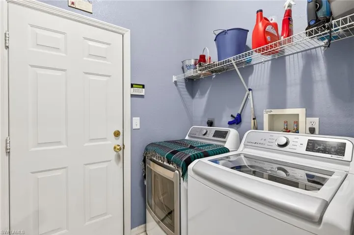 Laundry room with a textured wall and washer and dryer