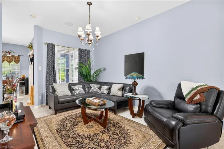 Living room featuring suspended lighting and light tile patterned floors