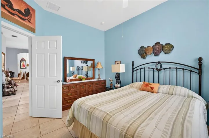 Bedroom with tile patterned floors, a ceiling fan, and lofted ceiling