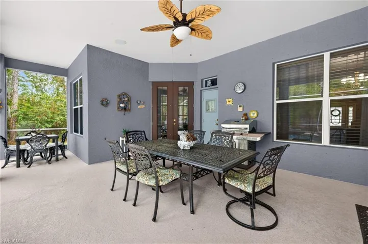 Dining space with a textured wall, french doors, light carpet, and ceiling fan