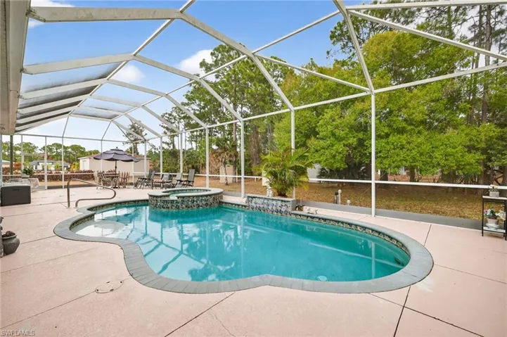 Integrated pool / spa with a lanai, a sunroom, and a patio area
