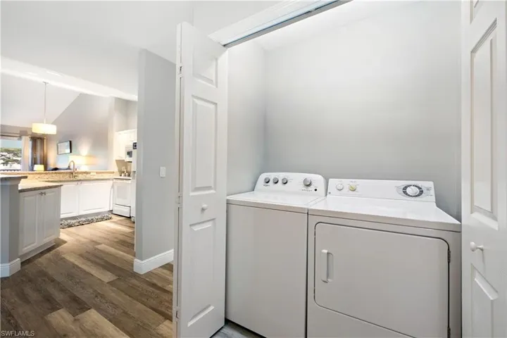 Washroom with separate washer and dryer and wood finished floors