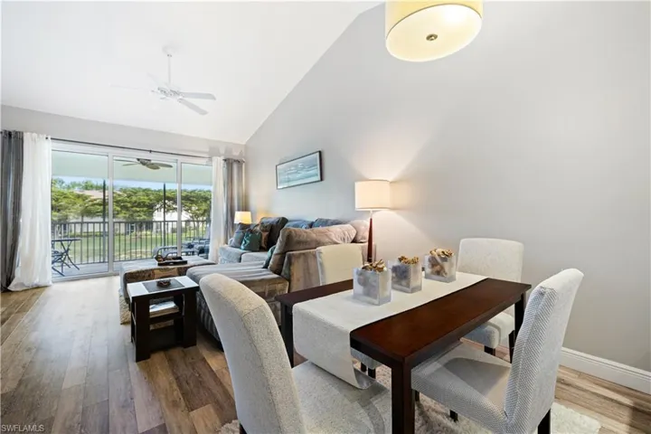 Dining area featuring a ceiling fan, wood finished floors, and high vaulted ceiling