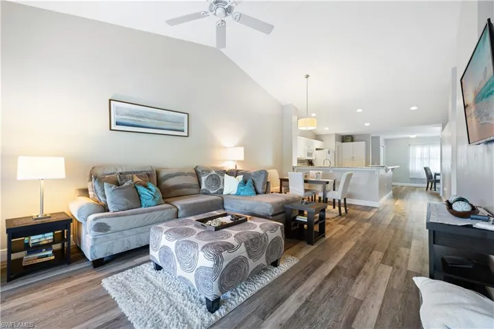 Living area with wood finished floors, a ceiling fan, recessed lighting, and high vaulted ceiling