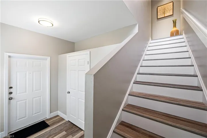 Stairs featuring wood finished floors