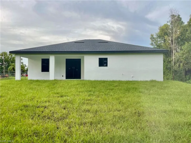 Back of house featuring a yard