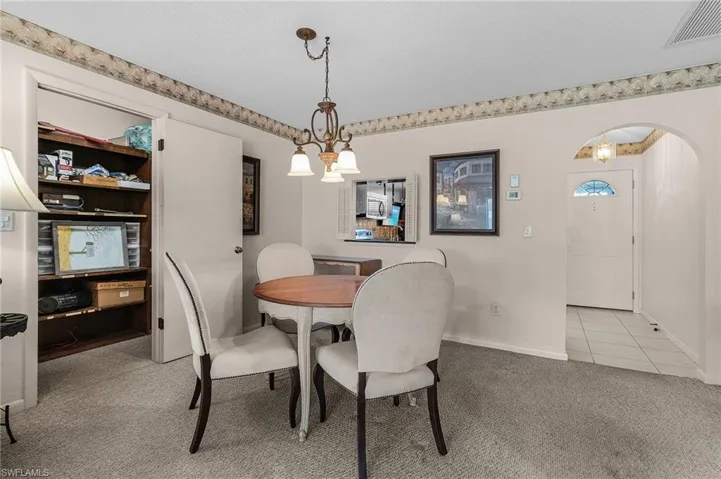 This view shows the interior of the in-residence storage that has plenty of organizational shelves. Another arch is visible into the foyer of the residence.