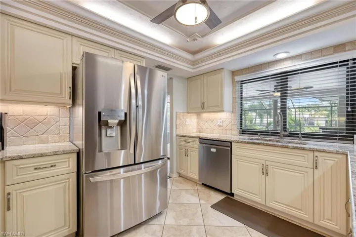 Kitchen featuring ceiling fan, tasteful backsplash, cream cabinetry, sink, and appliances with stainless steel finishes