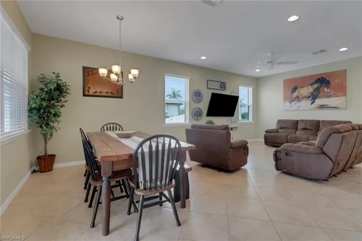 Dining area featuring recessed lighting, light tile patterned floors, a chandelier, baseboards, and a ceiling fan