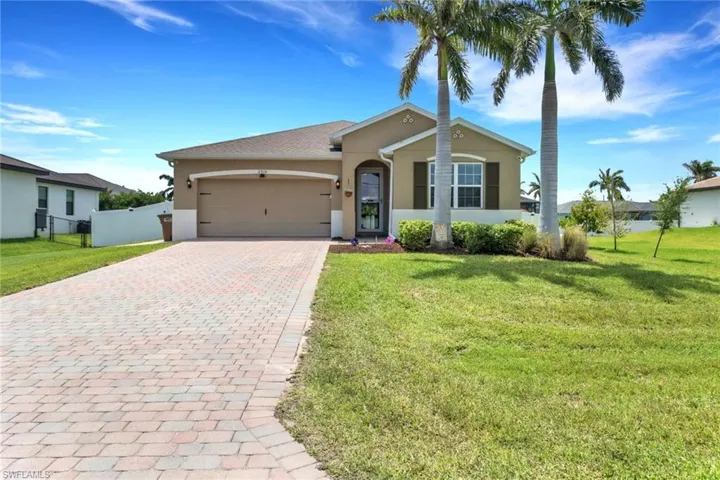 Ranch-style home with stucco siding, decorative driveway, and an attached garage