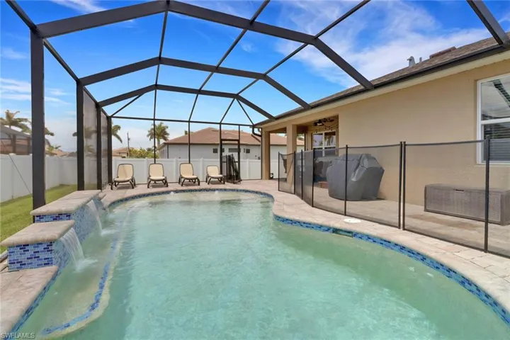 View of swimming pool featuring a patio area, a ceiling fan, and a lanai