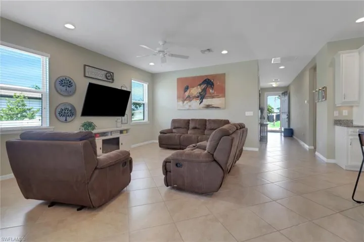 Living area featuring recessed lighting, a ceiling fan, light tile patterned floors, and plenty of natural light