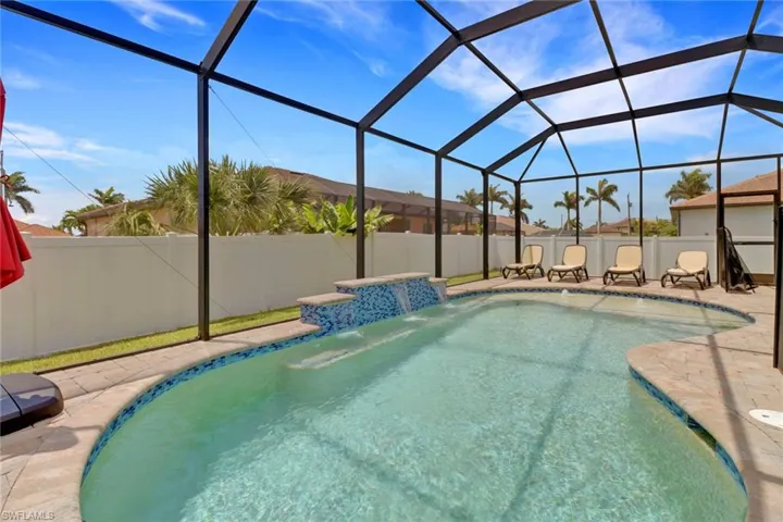 View of pool with a patio and glass enclosure