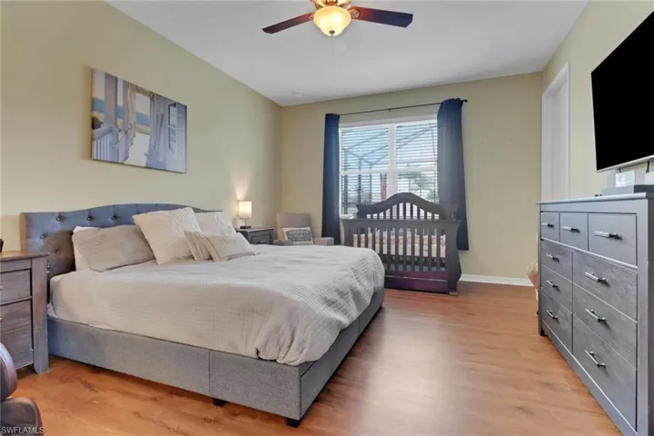 Bedroom featuring wood finished floors, baseboards, and ceiling fan