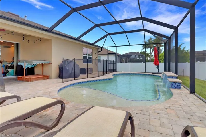 View of swimming pool with a patio area and glass enclosure