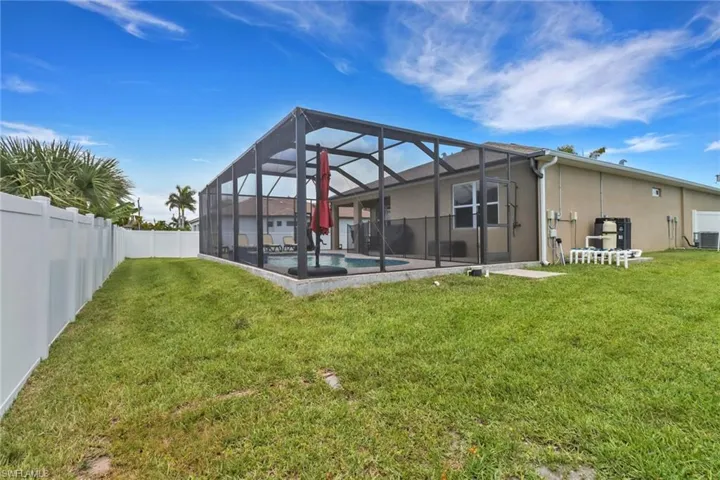 Rear view of property with central AC unit, glass enclosure, and stucco siding