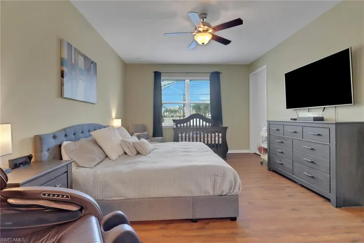 Bedroom featuring wood finished floors, baseboards, and ceiling fan
