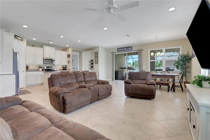 Living area featuring a chandelier, ceiling fan, recessed lighting, and light tile patterned floors