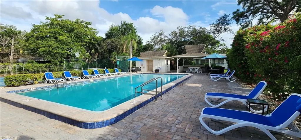 Community pool featuring a patio area and an outbuilding