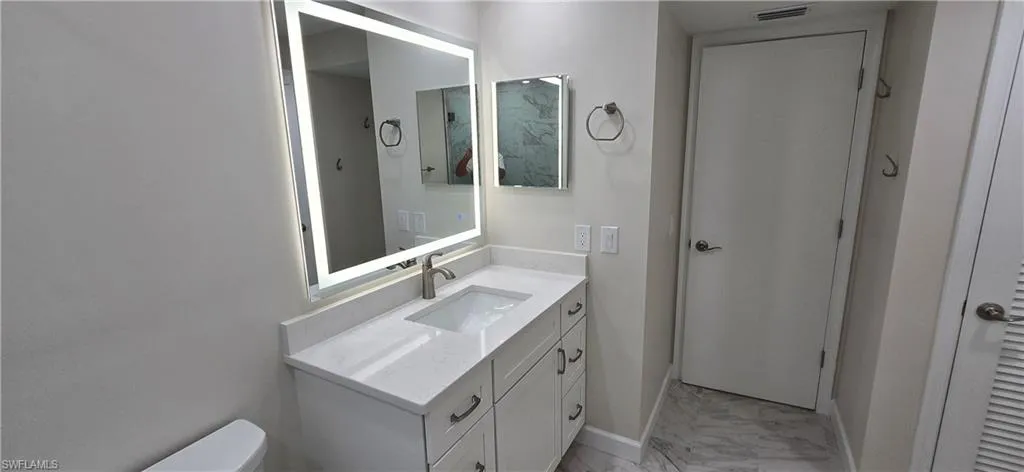 Second Bathroom featuring vanity and light marble finish floors, En-suite & Hall Access.