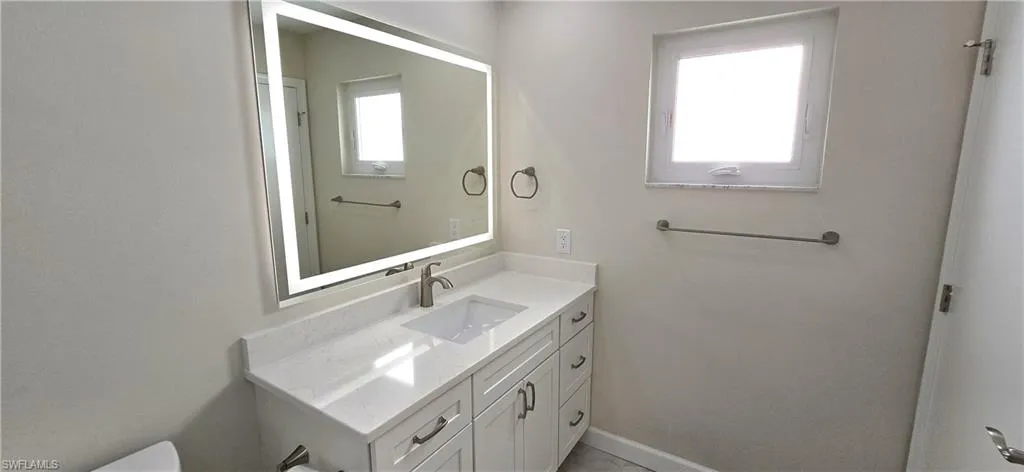 Half bath featuring vanity and baseboards