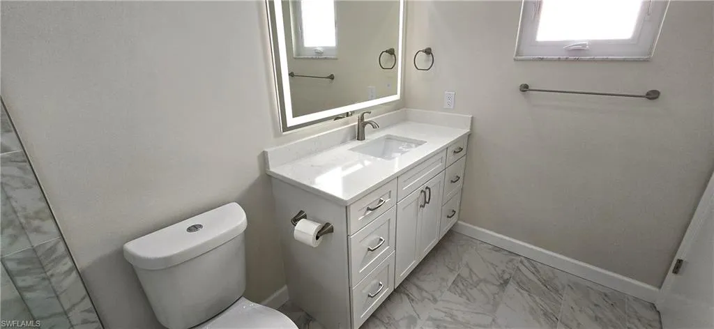 Bathroom featuring vanity and light marble finish floors