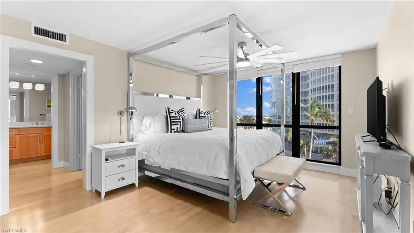 Primary Suite featuring light hardwood / wood-style floors, ceiling fan, and ensuite bath