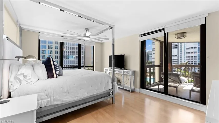 Primary Suite with ceiling fan, light hardwood / wood-style flooring, a wall of windows, and access to outside