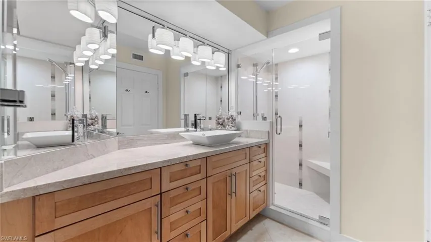 Guest Bathroom with vanity, an enclosed shower, and tile patterned flooring