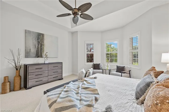 Carpeted bedroom featuring ceiling fan