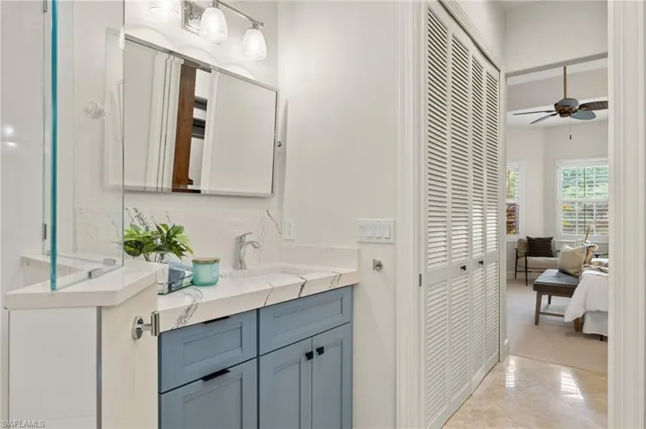 Bathroom featuring tile patterned floors, vanity, and ceiling fan