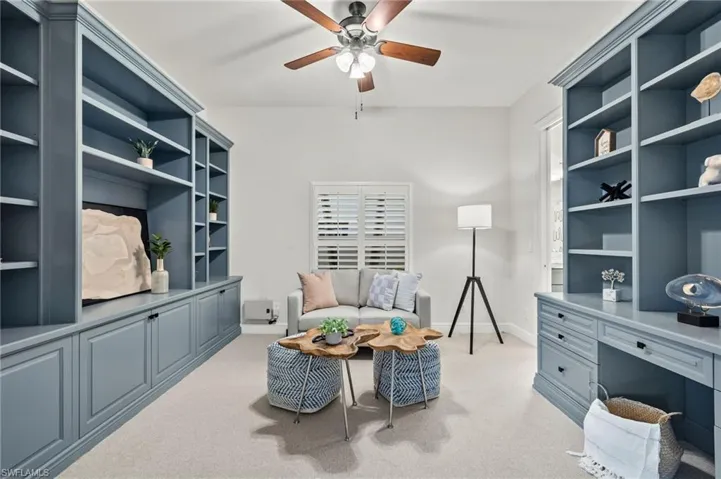 Home office with light carpet and ceiling fan