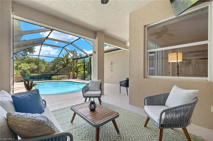 View of swimming pool with a patio, glass enclosure, ceiling fan, and outdoor lounge area