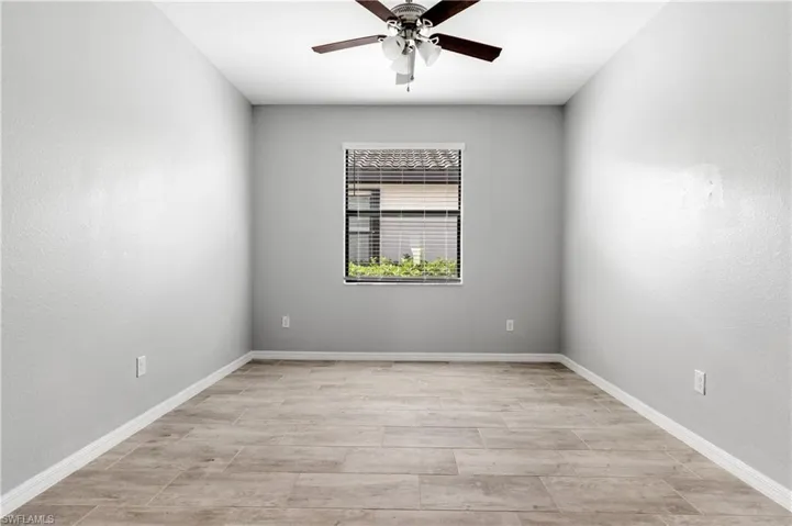 Unfurnished room featuring ceiling fan and baseboards