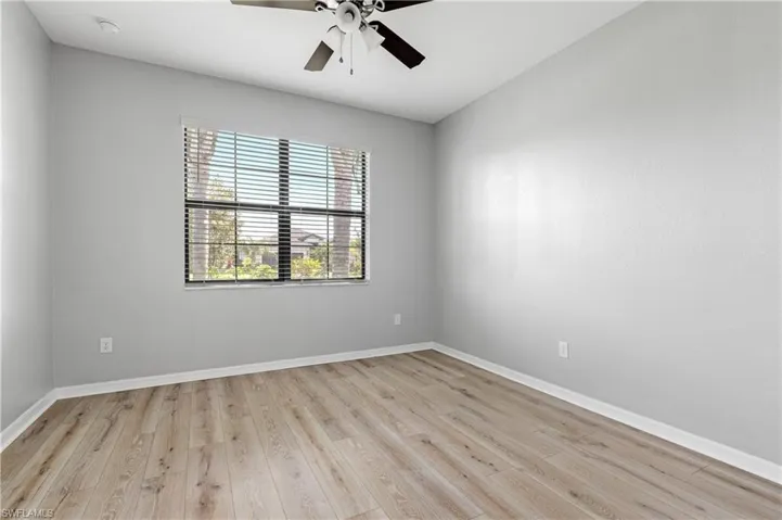 Empty room featuring baseboards, a ceiling fan, and light wood finished floors