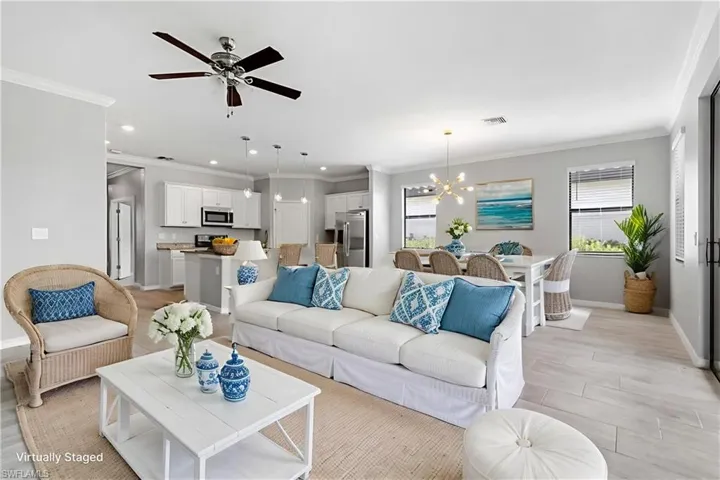 Living area featuring plenty of natural light, a chandelier, recessed lighting, crown molding, and ceiling fan