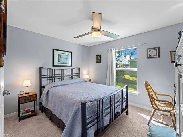 Bedroom with light carpet and a ceiling fan