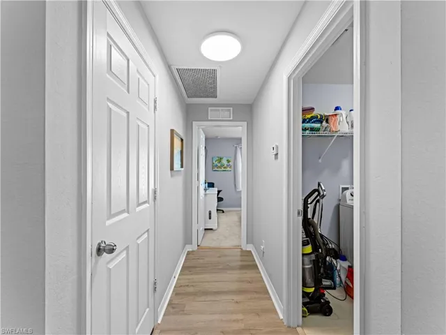 garage/laundry room/guest room-Hallway with light wood-style flooring and baseboards