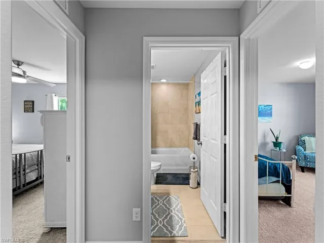 Hall featuring light carpet and light tile patterned floors