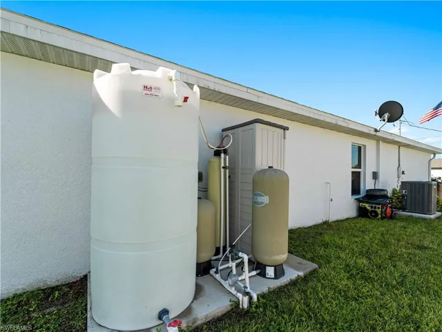 Exterior view of a central AC unit and stucco siding