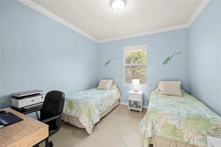 Bedroom featuring ornamental molding, a desk, and light tile patterned floors
