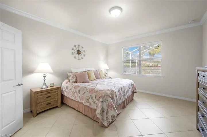 Bedroom featuring crown molding and light tile patterned flooring