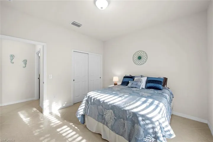 Bedroom featuring light tile patterned floors and a closet