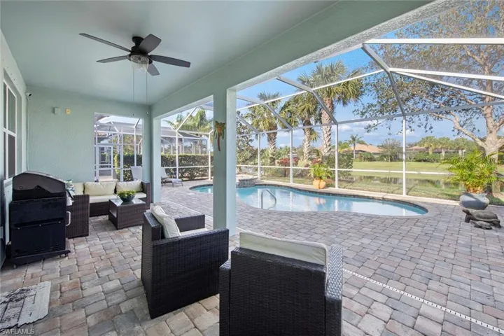 Swimming pool with glass enclosure, a sunroom, a patio area, grilling area, and outdoor lounge area