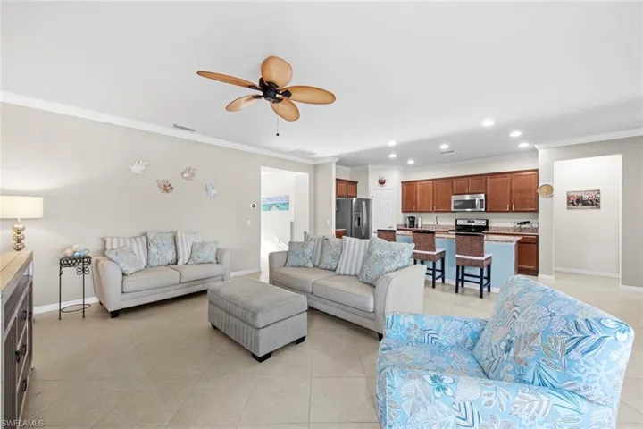Living room featuring crown molding, recessed lighting, light tile patterned floors, and ceiling fan