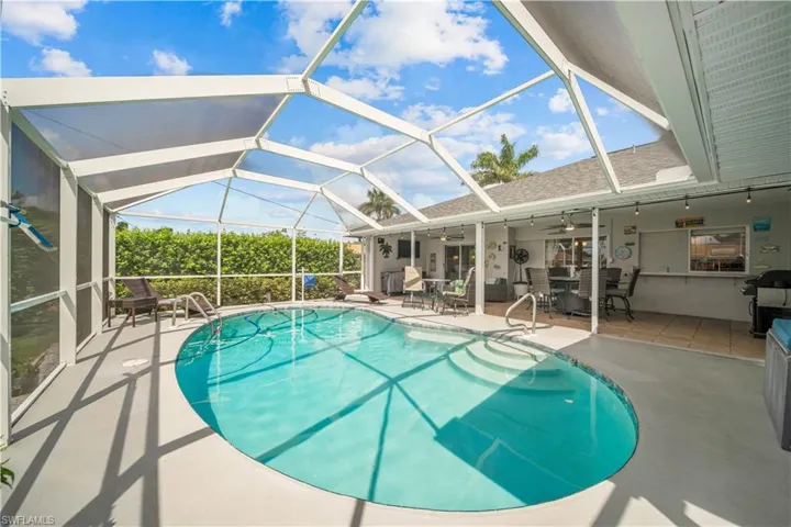 View of pool with a lanai, ceiling fan, area for grilling, and a patio area