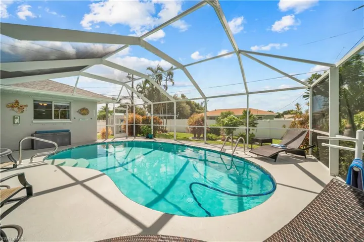 View of swimming pool featuring glass enclosure and a patio