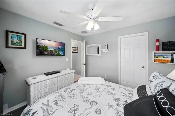 Bedroom with ceiling fan and wood-style tiled floors